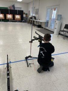 Youth competitor kneeling with air rifle at the 2021 Iowa State Championship
