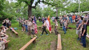 Boy Scouts carrying flags in a ceremony at the Izaak Walton League grounds
